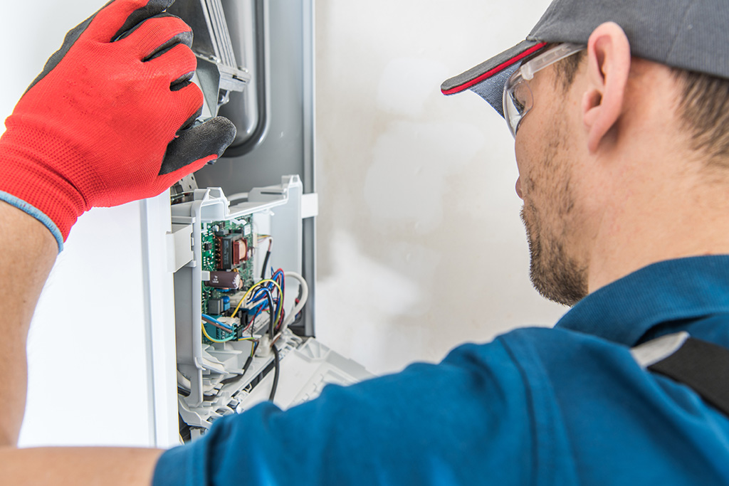 Technician Servicing Residential Heating Equipment. Central Heat Gas Furnace Issue. furnace cleaning chicago, furnace replacement, furnace installation